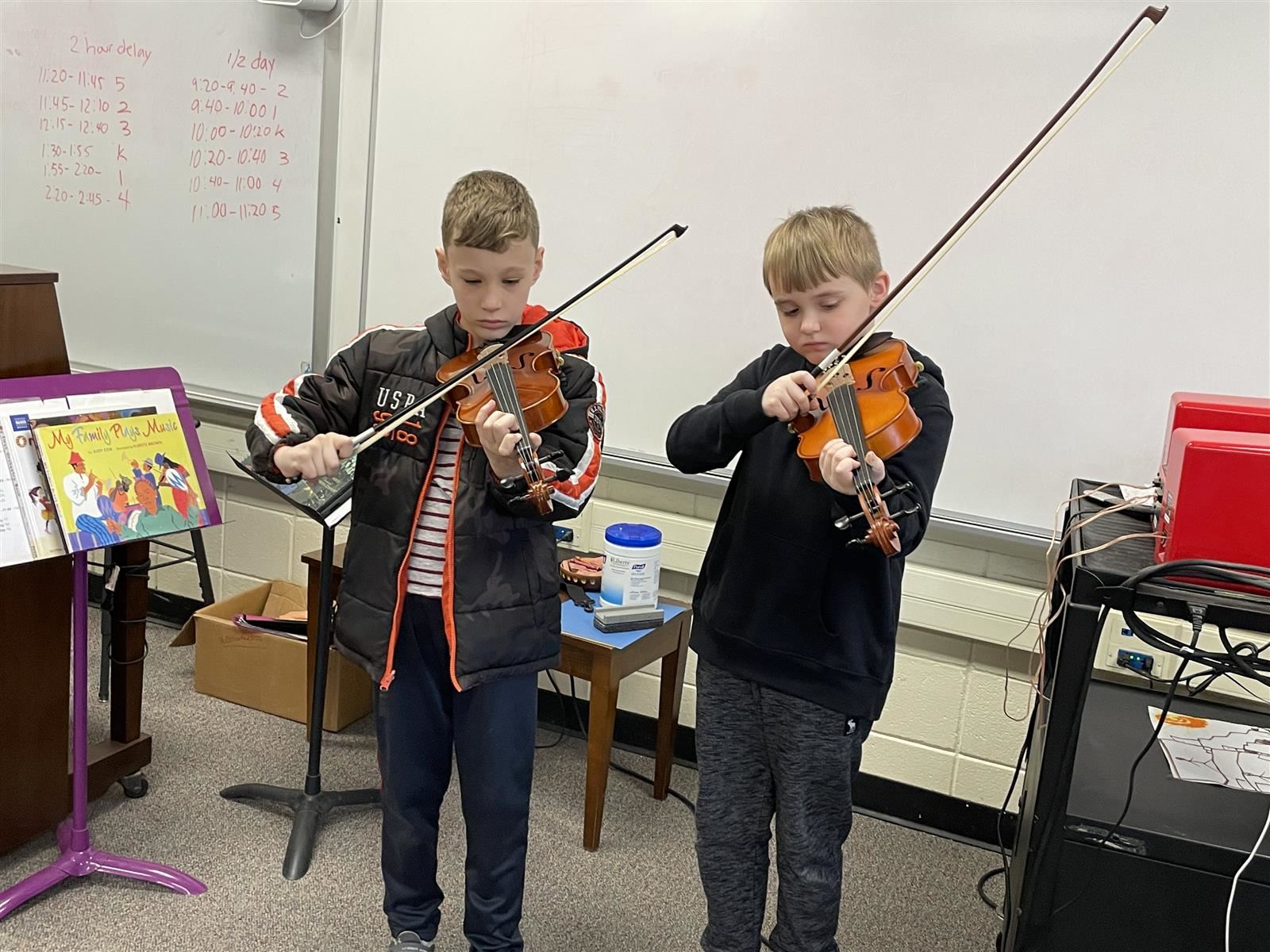  two students playing violins 